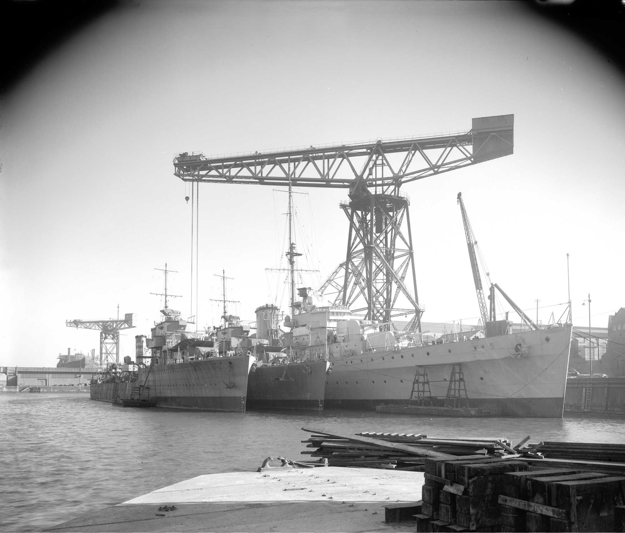 HMS Ajax fitting out in Devonshire Dock, with HMS Fame and HMS Firedrake moored alongside, 1st June 1935.