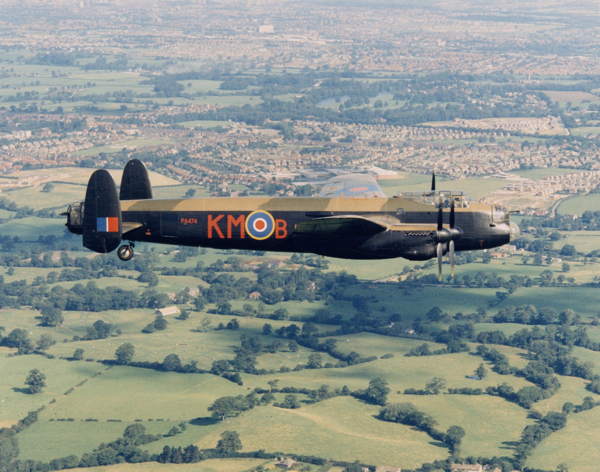 View of the Battle of Britain Memorial Flight Avro 683 Lancaster B.1 (PA474), flying over countryside, April 1997